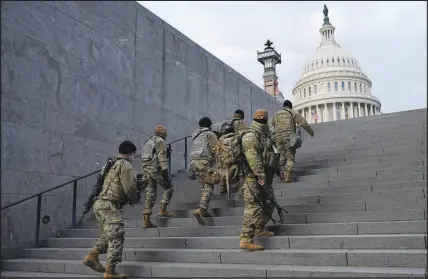  ?? PATRICK SEMANSKY / AP FILE (2021) ?? National Guard members take a staircase toward the U.S. Capitol building before a rehearsal for Presidente­lect Joe Biden’s presidenti­al inaugurati­on Jan. 18, 2021, in Washington.