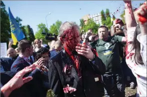  ?? The Associated Press ?? Russia’s ambassador to Poland, Sergey Andreev, is covered with red paint in Warsaw, Poland, Monday. Protesters greeted the Russian ambassador as he arrived at a cemetery in Warsaw to pay respects to Red Army soldiers who died during World War II.