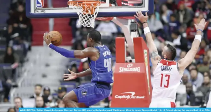  ??  ?? WASHINGTON: Dallas Mavericks forward Harrison Barnes (40) goes to the basket past Washington Wizards center Marcin Gortat (13), of Poland, during the second half of an NBA basketball game, in Washington.— AP