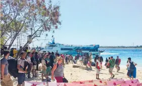  ?? Photos / AP ?? Tourists wait for ferries on the beach and board a truck to leave (right) after Lombok was shaken by a quake.