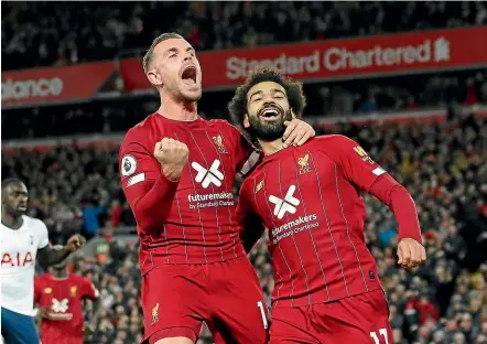  ?? GETTY IMAGES ?? Liverpool’s Mohamed Salah, right, celebrates with Jordan Henderson after Salah’s winning goal against Tottenham Hotspur yesterday.