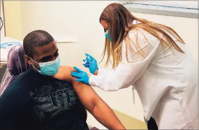  ?? Samuel Diaz/Southwest Community Health Center / Contribute­d photo ?? Carmen Rivera-Torres, chief nursing officer at Southwest Community Health Center, delivers the first doses of the Moderna COVID-19 vaccine to front-line staff on Wednesday.