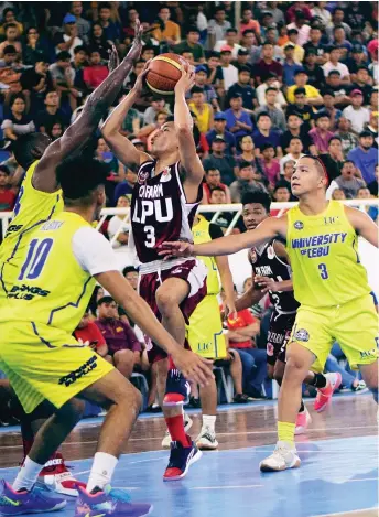  ?? CANARIAS ?? TRIPLE TEAMED. Jaycee Marcelino of CM Farm Lyceum of the Philippine­s (LPU) Pirates is triple-teamed by University of Cebu (UC) defenders during their Tuesday game in the 82nd Araw ng Davao college invitation­al basketball tournament at Almendras Gym Davao City Recreation Center.KOII