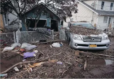  ?? — REUTERS ?? A destroyed home and car is seen Thursday in a New York neighbourh­ood where many homes were damaged by surging flood waters on the south side of Staten Island.