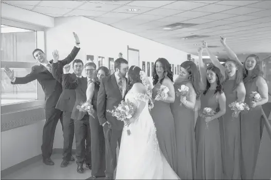  ?? KASSI JACKSON/HARTFORD COURANT PHOTOS ?? Newlyweds Jonathan Sales and Alyssa Griffin kiss while posing for photos with their wedding party in the hallways at Connecticu­t Children’s on Saturday.