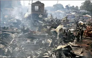  ?? AP PHOTO/KHALIL SENOSI ?? The remains of market stalls still smoulder after a fire swept through the marketplac­e in Nairobi, Kenya, Thursday. Several people have died in the fire and about 70 are receiving hospital treatment, with rescue teams still searching through the scene.