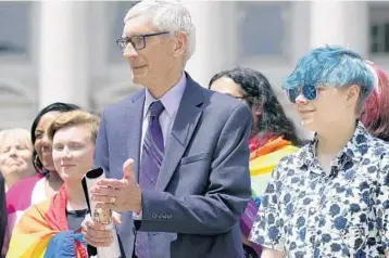  ?? MARK HOFFMAN/MILWAUKEE JOURNAL-SENTINEL ?? Wisconsin Gov. Tony Evers, left, attends a Rainbow Pride flag raising Wednesday in Madison. Evers, who is up for reelection, warned that if he loses, the GOP will push to ban books with LGBTQ themes.