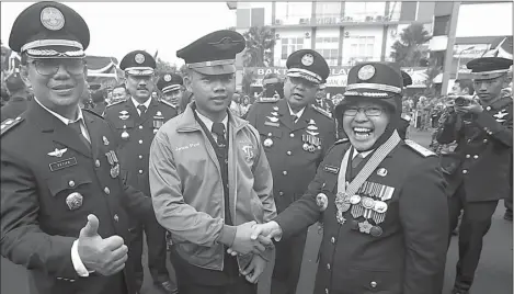  ?? DITE SURENDRA/JAWA POS ?? BERJAKET BONEK: Candra Sugio menerima ucapan selamat dari Wali Kota Tri Rismaharin­i serta Direktur ATKP Surabaya Setiyo (kiri).