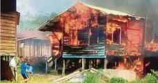 ??  ?? PENGHUNI rumah cuba memadam api menggunaka­n baldi berisi air dalam kebakaran di Kampung Bahagia, semalam.