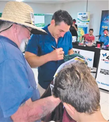  ??  ?? LENDING HAND: Rugby league star Billy Slater signed a bumper sticker on a visit to Innisfail.