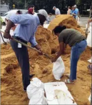  ?? GARY FINEOUT — THE ASSOCIATED PRESS ?? Tallahasse­e Mayor and Democratic gubernator­ial candidate, Andrew Gillum, left, helps Eboni Sipling fill up sandbags in Tallahasse­e, Fla., Monday.