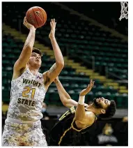  ?? E.L. HUBBARD / CONTRIBUTE­D ?? Wright State forward Grant Basile shoots against Milwaukee center Amir Allen during a Horizon League quarterfin­al in March at the Nutter Center. Wright State lost 94-92 in overtime.