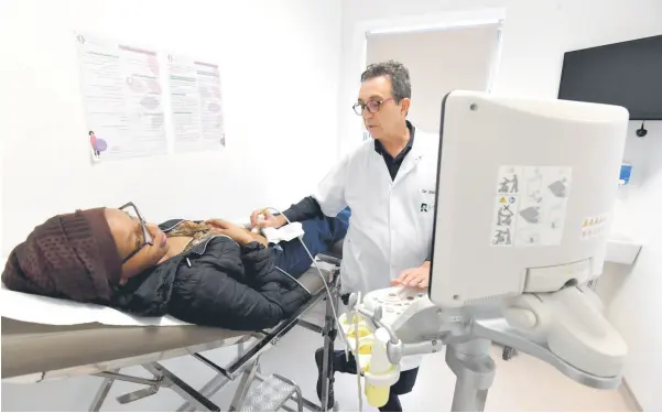  ?? — AFP photos ?? Tunisian doctor and professor of gynecology Fethi Zhiwa specializi­ng in infertilit­y, examines Yunoussa at a clinic in Tunis.