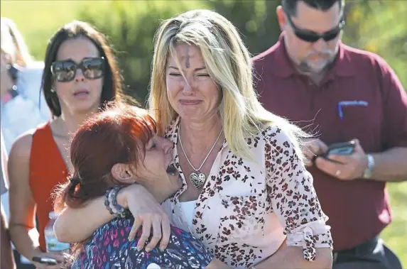  ?? Joel Auerbach/Associated Press ?? Parents wait for news after reports of a shooting at Marjory Stoneman Douglas High School on Wednesday in Parkland, Fla.
