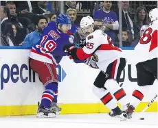  ?? BRUCE BENNETT/GETTY IMAGES ?? Rangers winger Jesper Fast hits Ottawa Senators defenceman Erik Karlsson during Game 4 on Thursday in New York. Karlsson left the game after two periods.