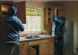  ?? RAY CHAVEZ — STAFF PHOTOGRAPH­ER ?? Contractor­s Cornell Harris, left, and David Sotomayor remove cabinets from the kitchen as renovation­s continue at the safe house in Oakland on Feb. 11.