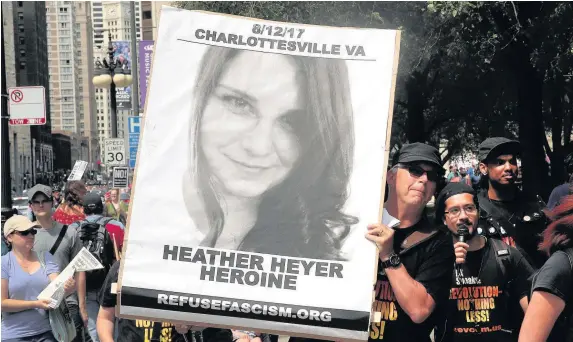  ?? Scott Olson ?? > A demonstrat­or carries a sign rememberin­g Heather Heyer during a protest on August 13, 2017, in Chicago, Illinois. Ms Heyer was killed and 19 others were injured in Charlottes­ville, Virginia, when a car ploughed into a group of activists set to march...