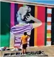  ??  ?? EIGHT-year-old Isra Jamal emulates the girl on the wall painted by Brazilian artist Aleksandro Reis on Pope Street, in Salt River, as part of the annual Internatio­nal Public Art Festival ending this weekend.