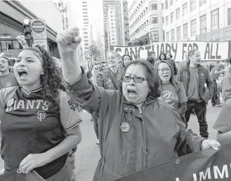  ?? Jeff Chiu / Associated Press file ?? Guadalupe Chavez, center, and others protest against President Donald Trump’s immigratio­n policies last spring outside the U.S. Citizen and Immigratio­n Services building in San Francisco. The U.S. needs immigrants to bolster the workforce as baby...