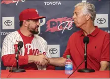  ?? JOSE F. MORENA — THE PHILADELPH­IA INQUIRER VIA AP ?? New Phillies outfielder and/or designated hitter Kyle Schwarber, left, shakes hands with Phillies President of Baseball Operations Dave Dombrowski Monday in Clearwater, Fla.