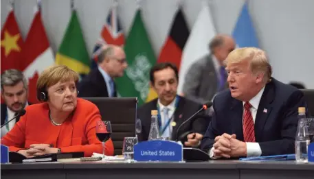  ?? GETTY IMAGES PHOTOS ?? SUMMIT’S PEAK: German Chancellor Angela Merkel listens as President Trump addresses the G-20 summit yesterday in Buenos Aires, Argentina. Below, Russian President Vladimir Putin shakes hands with Saudi Crown Prince Mohammed bin Salman.