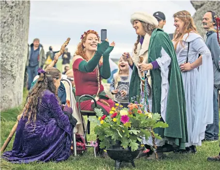  ??  ?? Dressed for the occasion, a woman takes a selfie as hundreds of druids and pagans flocked to Stonehenge, hoping to see the sun rise to celebrate the autumn equinox and the dawning of the new season yesterday.