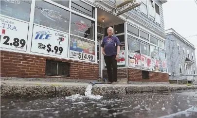  ?? STAFF PHOTOS BY FAITH NINIVAGGI ?? ‘IT’S BRUTAL’: Peter Loomos of Loomos Bros. Liquor Store in Lynn watches as gallons of water are pumped out after heavy rains caused floor-to-ceiling water in the basement, below right.