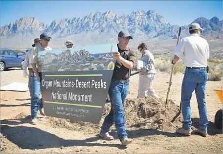  ?? Jett Loe Las Cruces Sun-News ?? WORKERS INSTALL a sign in March 2015 at a newly designated national monument in New Mexico. The sign and others may come back down under President Trump, who has ordered the review of more than 20 national monuments designated by the last three...