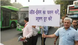  ?? — BIPLAB BANERJEE ?? Transport minister Kailash Gahlot displays a placard asking people to obey the odd-even rule at ITO in New Delhi on Monday.