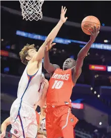  ?? MARK J. TERRILL/ASSOCIATED PRESS ?? New Mexico forward Makuach Maluach puts up a shot inside as St. Mary’s center Jordan Hunter goes for a block.