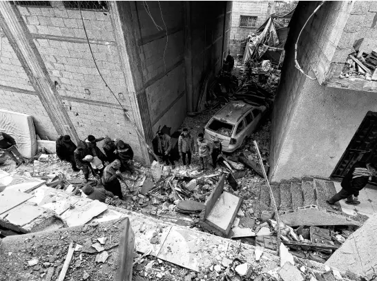  ?? REUTERS ?? Palestinia­ns inspect the site of an Israeli strike on a house in Rafah, in the southern Gaza Strip, on March 19 amid the ongoing conflict between Israel and Hamas.