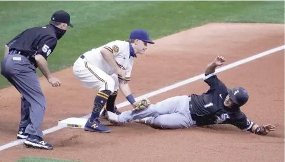  ??  ?? Brewers third baseman Brock Holt tags out the Sox’ Nick Madrigal, who injured his shoulder on this slide in the third inning while trying to advance from first. MORRY GASH/AP