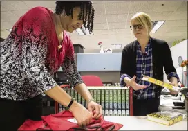  ?? ALYSSA POINTER / AJC.COM ?? Ginny Collier (right), manager of collection­s management at the Atlanta Central Library, and Charmaine Johnson, assistant manager, prepare a leased copy of the new Walter Mosley novel for distributi­on at the library Friday.