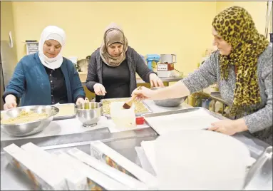  ?? Peter Hvizdak / Hearst Connecticu­t Media ?? From left, Faten Natfai and Hala Ghali, both from Syria, and Nieda Abbas, from Iraq, make baklava at Katalina’s bakery on Whitney Avenue in New Haven for Yale “butteries,” late-night cafes at Yale run by refugee chefs and sponsored by Integrated Refugee and Immigrant Services.