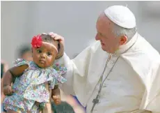  ?? — Reuters ?? Pope Francis blesses a child as he arrives to lead the Wednesday general audience in Saint Peter’s square at the Vatican, on Wednesday.