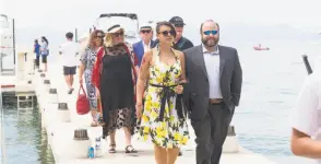  ?? Devlin Shand / Drew Altizer Photograph­y ?? A regal red gown, from top, from the Oscar de la Renta Resort 2018 collection, rules the runway at the League to Save Lake Tahoe fashion show with Saks Fifth Avenue; guests arrive by boat; young Myle (left) and Annabelle Zagorsky rock complement­ary...