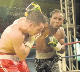  ?? FILE ?? Jamaica’s Richard ‘Frog’ Holmes (right) delivers a heavy right to the head of Canadian Frank Cotroni during their Wray & Nephew Contender Boxing Series quarter-final match at the Chinese Benevolent Associatio­n Auditorium on Wednesday, June 14, 2017.