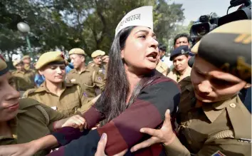  ?? — PTI ?? Police personnel detain AAP leader Alka Lamba during a protest outside Union home minister Rajnath Singh’s residence in New Delhi on Thursday. AAP workers on Thursday staged a protest outside Mr Singh’s residence after he condemned the alleged assault...