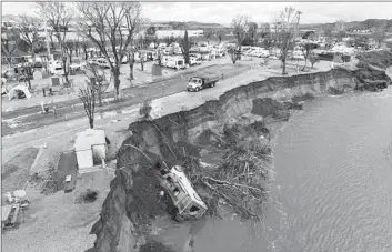  ?? Myung J. Chun Los Angeles Times ?? A RECREATION­AL VEHICLE lies at the bottom of a storm-damaged cliff in the Santa Clara River in 2023.