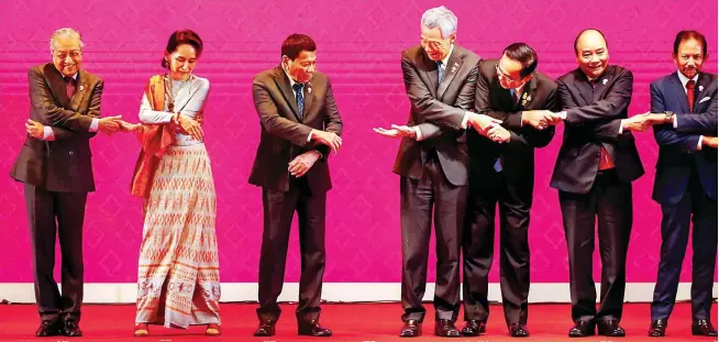  ?? (EPA-EFE) ?? LINKING LEADERS – (From left) Prime Minister Mahathir Mohamad of Malaysia, State Counselor Aung San Suu Kyi of Myanmar, President Duterte, Prime Minister Lee Hsien Loong of Singapore, Prime Minister Prayut Chan-o-cha of Thailand, Prime Minister Nguyen Xuan Phuc of Vietnam, and Sultan Hassanal Bolkiah of Brunei link hands during a group photo at the opening ceremony of the ASEAN Summit in Nonthaburi, Thailand.