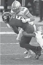  ?? JOSHUA A. BICKEL/ COLUMBUS DISPATCH ?? Cade Stover (16) tackles Michigan State’s Jayden Reed on a kickoff on Dec. 5. Stover moved from defensive end to tight end last year but played mostly special teams.