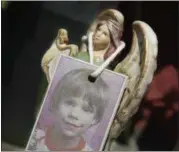  ?? MARK LENNIHAN —THE ASSOCIATED PRESS FILE ?? In this 2012, file photo, a photograph of Etan Patz hangs on an angel figurine, which is part of a makeshift memorial in the SoHo neighborho­od of New York.