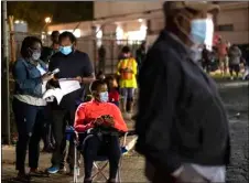  ?? BEN GRAY/ATLANTA JOURNAL-CONSTITUTI­ON VIA AP, FILE ?? In this Oct. 12 file photo, Denise and Bill Hasbune, of Stone Mountain, Ga., fill out a preregistr­ation form while waiting in line to vote at the DeKalb County elections office in Decatur, Ga.