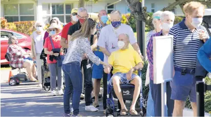  ?? LYNNE SLADKY/AP ?? Robert Birkenmeie­r, center, waits in line with other residents to receive the Pfizer-BioNTech COVID-19 vaccine on Tuesday at John Knox Village in Pompano Beach.