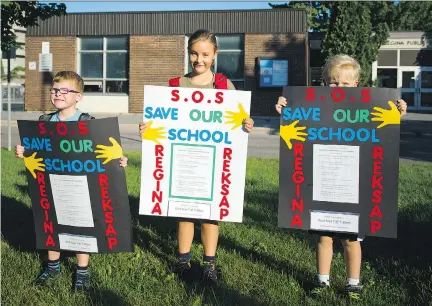  ?? ASHLEY FRASER/FILES ?? From left, Ryan Aikin, 6, Anna Weatherup, 9, and Adam Weatherup. 7, take a stand outside Regina Street Public School earlier this month.