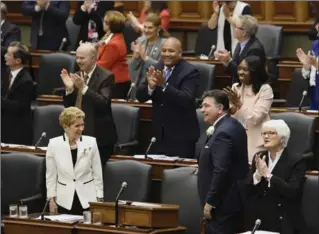  ?? NATHAN DENETTE, THE CANADIAN PRESS ?? Ontario Finance Minister Charles Sousa and Premier Kathleen Wynne, left, get a standing ovation as they enter the room to deliver the 2017 Ontario budget at Queen’s Park in Toronto on Thursday.