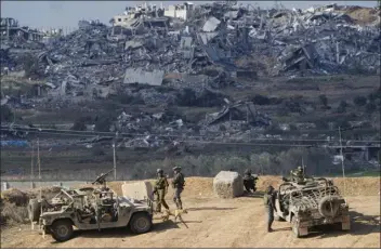  ?? AP PHOTO/ARIEL SCHALIT ?? Israeli soldiers take up positions near the Gaza Strip border, in southern Israel, Friday, Dec. 29, 2023.