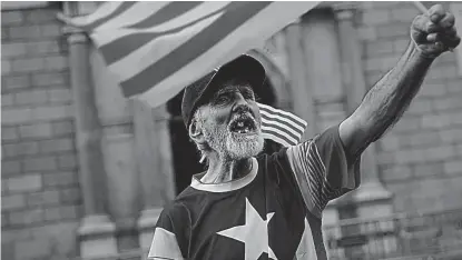  ?? (AP) ?? Reclamo en soledad. Un defensor de la independen­cia catalana, con sus banderas en la plaza Sant Jaume.