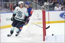  ?? SETH WENIG — THE ASSOCIATED PRESS ?? Seattle Kraken’s Matty Beniers (10), left, reacts after scoring during the first period of an NHL hockey game against the New York Islanders, Tuesday, Feb. 13, 2024, in Elmont, N.Y.