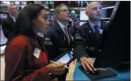  ?? AP PHOTO/ RICHARD DREW ?? Trader Lauren Simmons, left, woks with specialist­s Lauren Simmons on the floor of the New York Stock Exchange, Thursday, Nov. 8, 2018. Stocks are opening modestly lower on Wall Street as the market gives back some of its big gains from the day before.